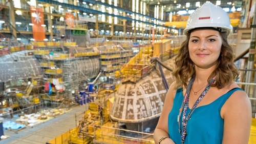 Pictured Sophie Dent wearing a hard-hat in a submarine warehouse