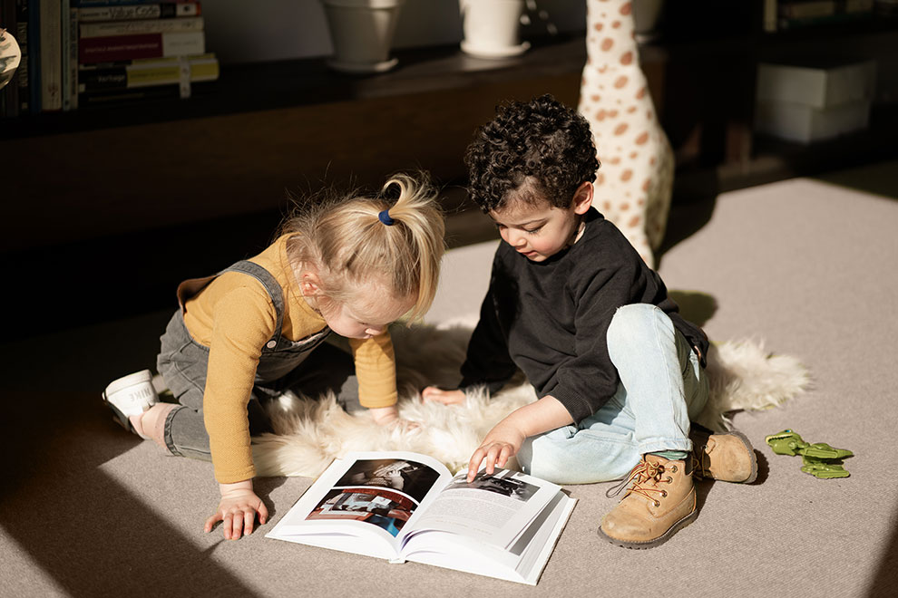 Kinderen bladerend door zelfgemaakte familieboek van Baby Diaries