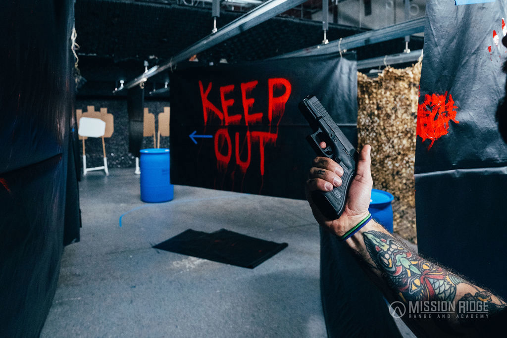 Shooter drawing on the KEEP OUT wall, red graffiti downrange