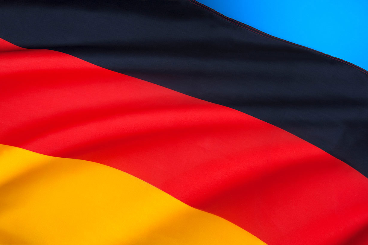 Nahaufnahme der deutschen Flagge mit den horizontalen Farben Schwarz, Rot und Gold, die im Wind weht.
