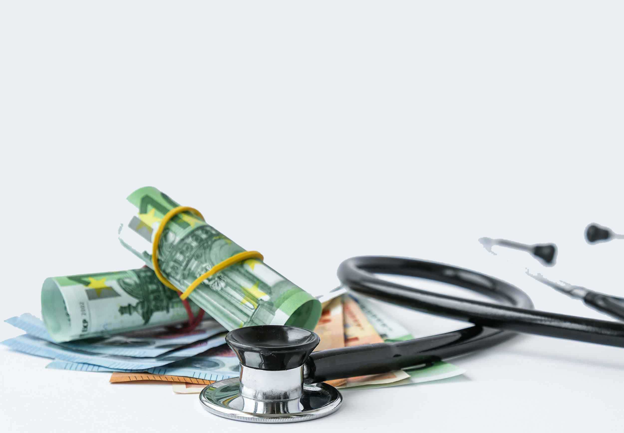 Ein Stapel Geldscheine, darunter Euro, mit einem Gummiband zusammengehalten, liegt neben einem Stethoskop. Das Wort „Insurance“ (Versicherung) steht prominent im Hintergrund.