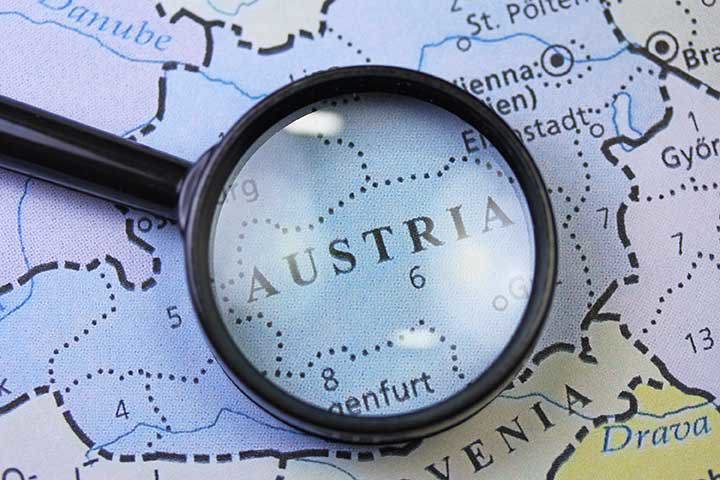 Eine Nahaufnahme einer Karte von Österreich, mit einer Lupe, die auf das Wort 