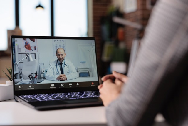 Pacientul are o consultație de telemedicină cu un medic prin laptop