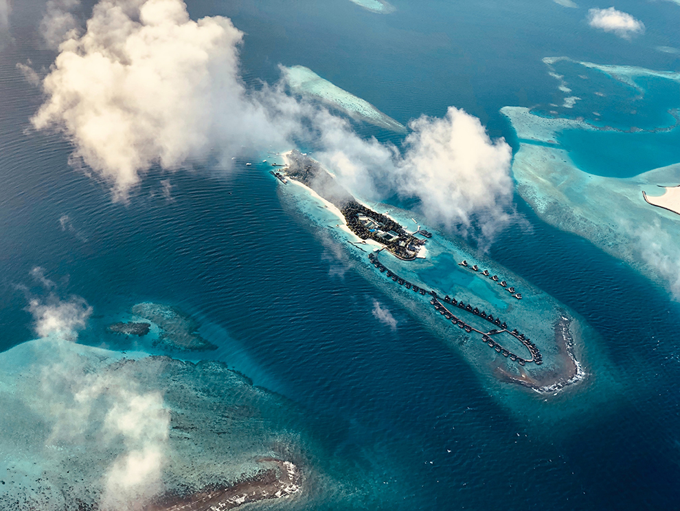 Dronfoto van klein tropisch eiland omringd door felblauwe zee