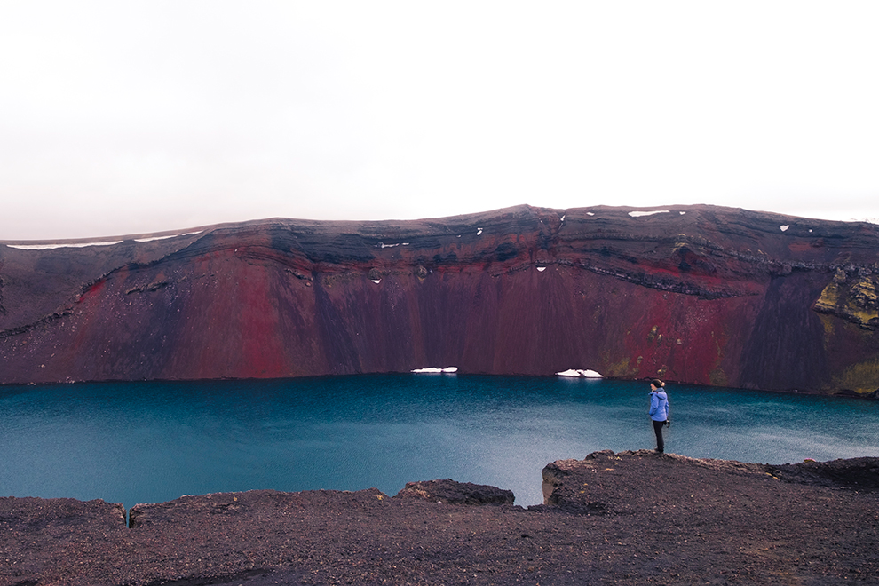 Helderblauw meer in rood kratergebied in IJsland