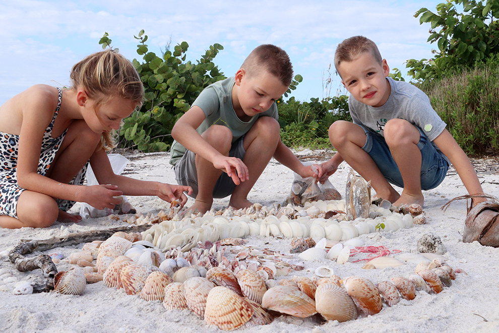 Kinderen verzamelen schelpen op het strand in Florida