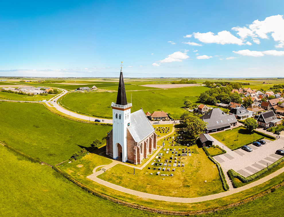 Witte kerkje midden in groen Texels landschap