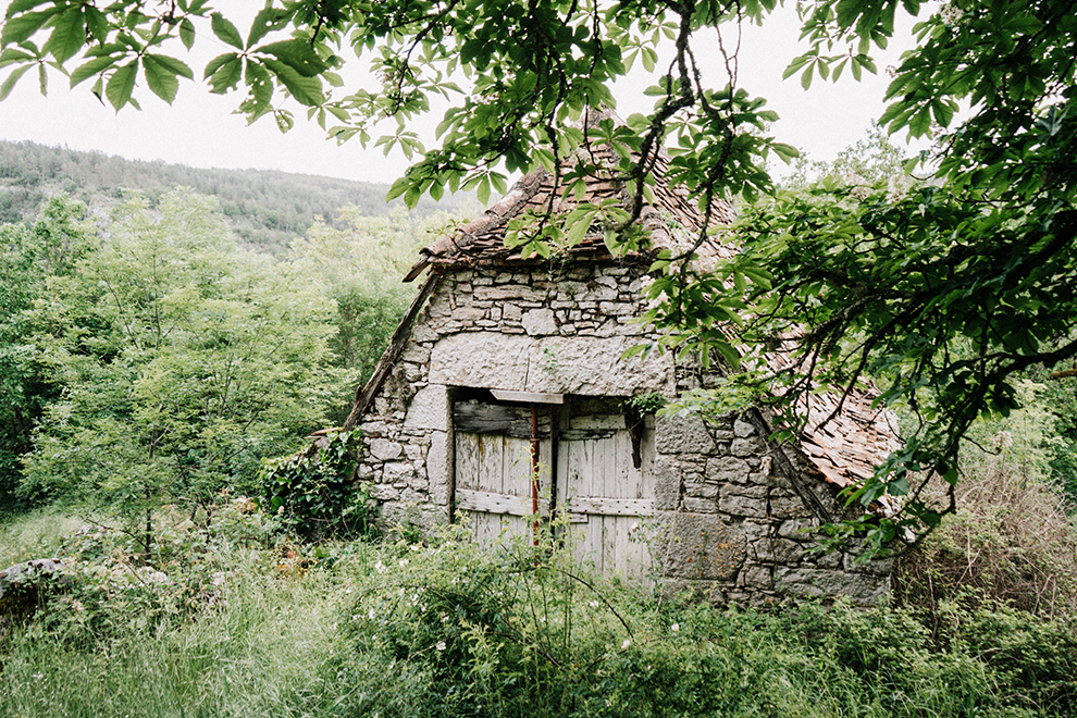 Verlaten stenen huis in de groene bergen bij Sauliac-sur-Célé