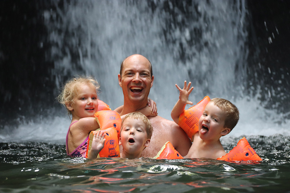 Vader met kinderen bij waterval in Costa Rica