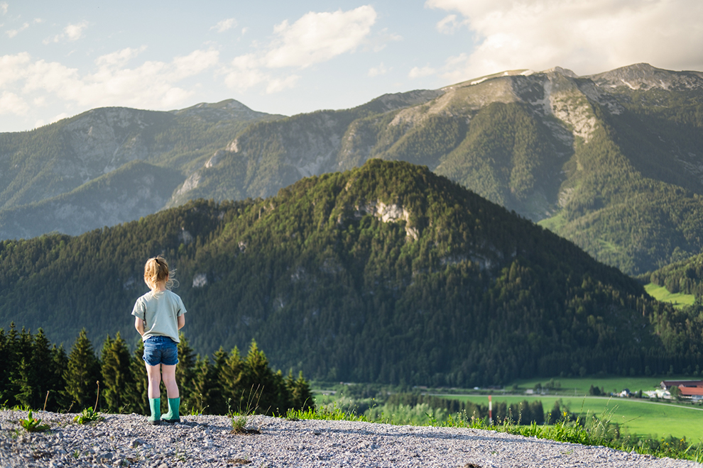 Kleine Maeve genietend van het uitzicht in de Oostenrijkse bergen
