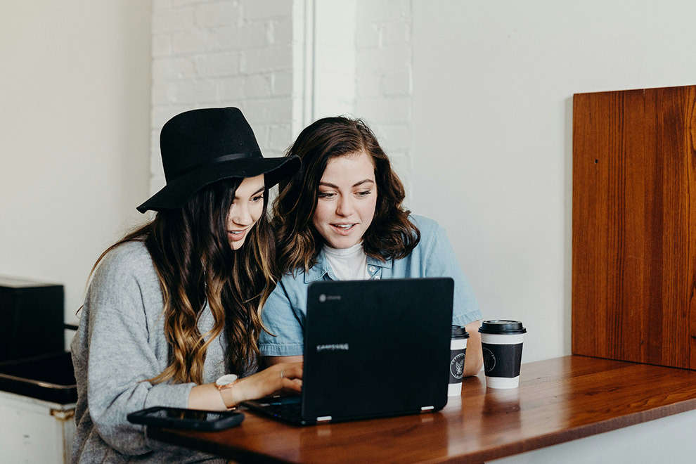 Two women working together on a laptop.