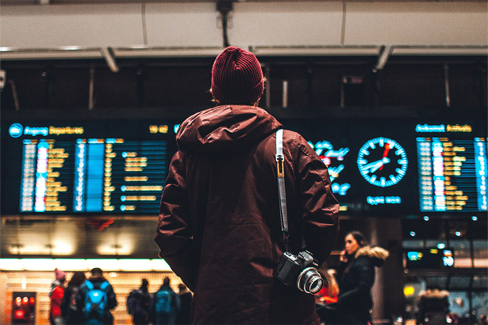 A person looks at the departures and arrivals at an airport.