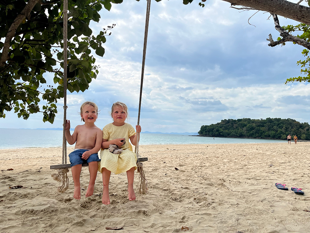 Kinderen op schommel aan het strand in Thailand