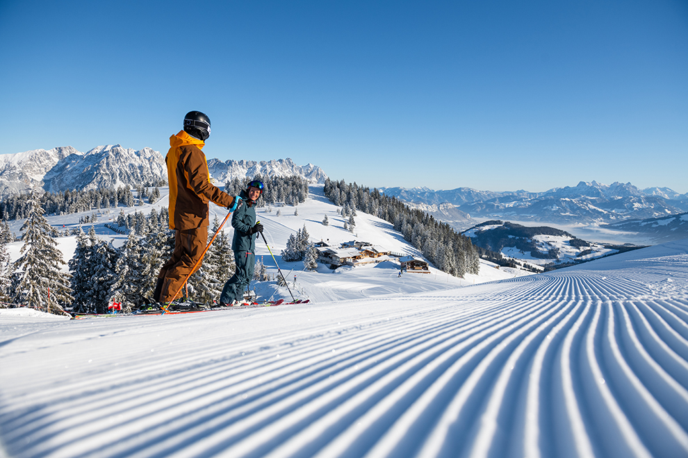 Twee Skiërs bovenop piste in Oostenrijk