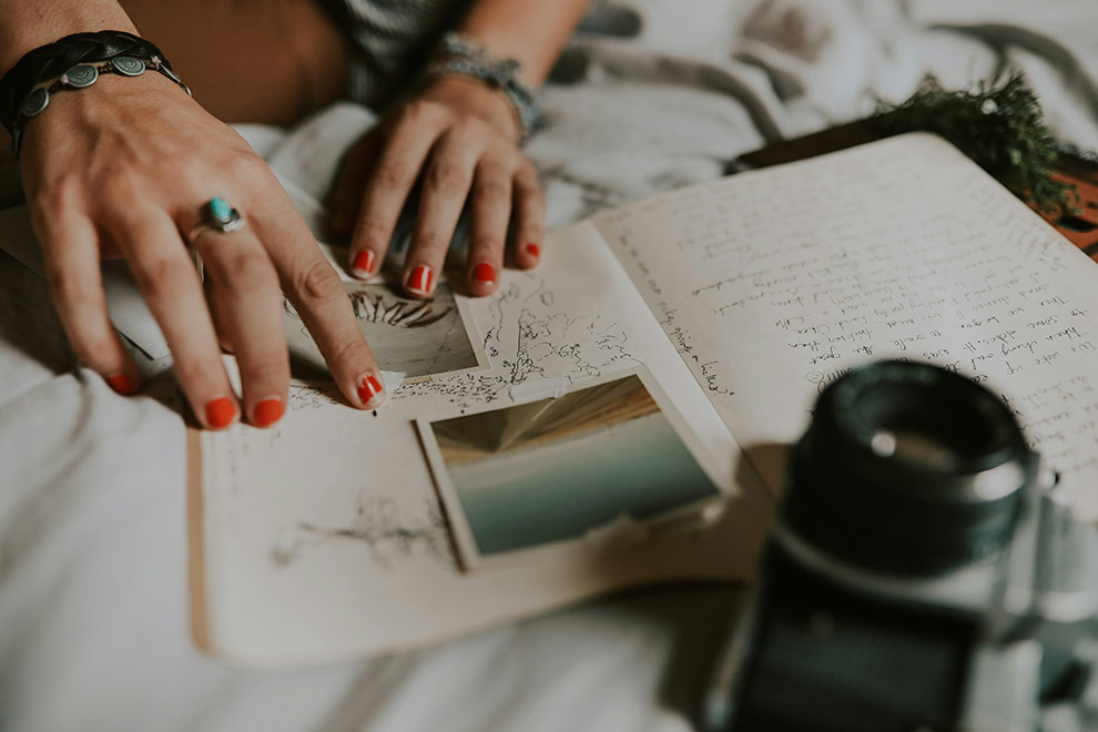 A woman putting pictures in her travel diary.