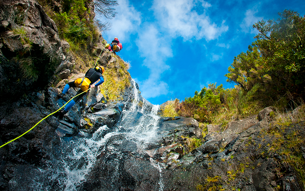 Canyoning van de rotsen bij waterval op Madeira