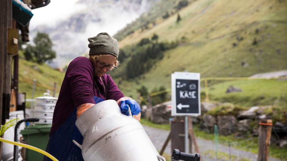 Vrouw in Zwitserland op maakt een melkvat schoon