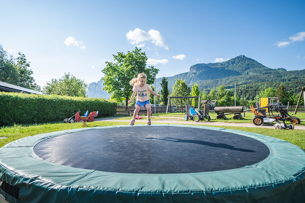 Dochter Maeve op trampoline in achtertuin hotel