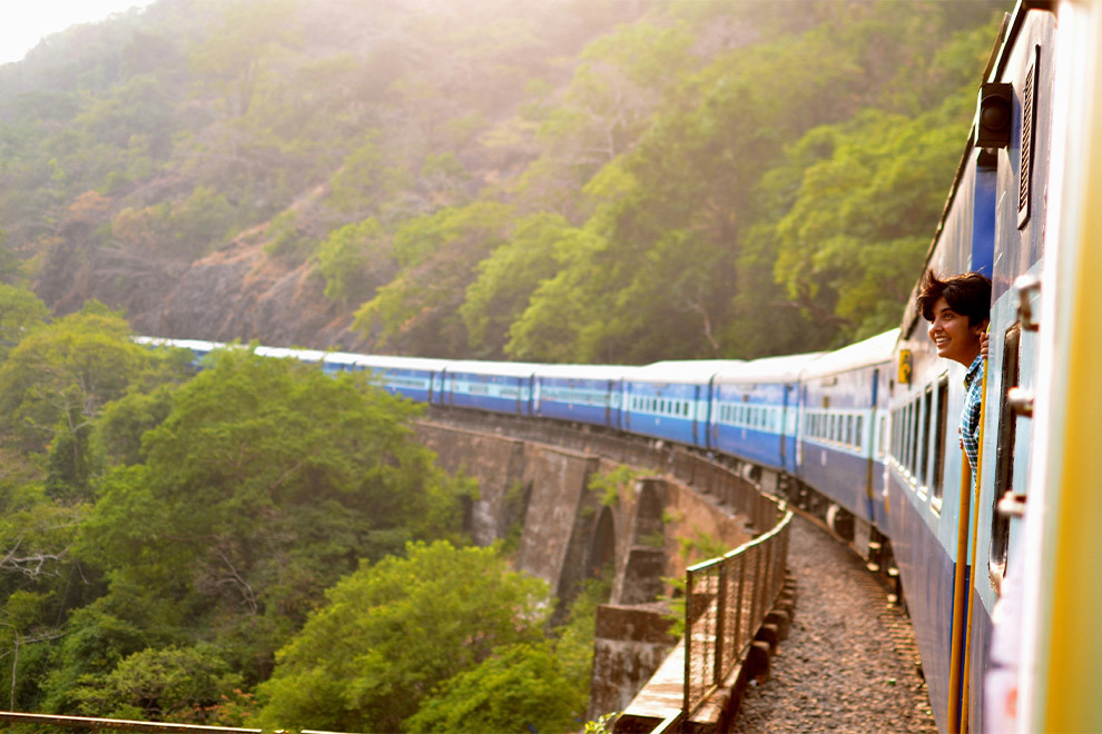 A person looks out of the window of a moving train.