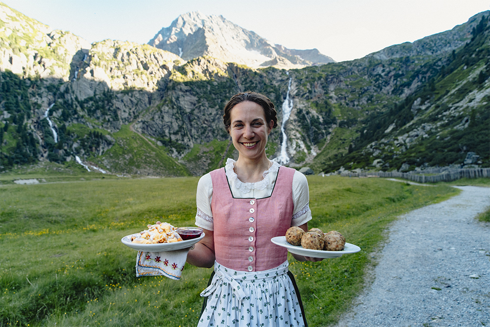 Traditionele gastvrouw en Tiroolse gerechten in de Oostenrijkse bergen