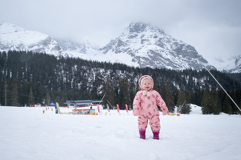 Kleine Maeve in de sneeuw tussen de Oostenrijkse bergtoppen